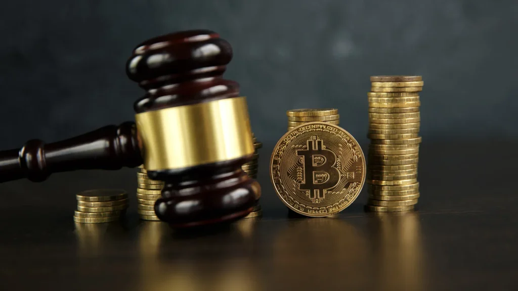 Auction gavel and bitcoin cryptocurrency money on a wooden desk