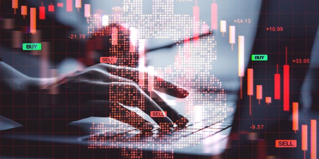 Hands typing with overlay of financial charts and a digital bitcoin symbol.jpg